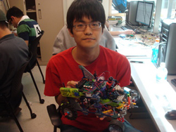 A student holding a microcontoller based robot car.