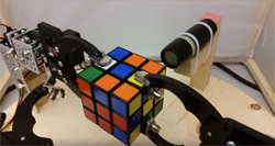 An FPGA-Based Robotic Rubik's Cube Solver We tasked ourselves with designing a mechanical Rubik’s cube solver. The mechanical arms rotate the cube to show each cube face of the cube to the camera. After each face is scanned, the cube faces are passed into the Rubik’s cube solving algorithm. The algorithm computes the moves that will be needed to solve the cube using a Nios II processor. The instructions are then fed to the FPGA, which in turn sends PWM signals to the servos to rotate the cube accordingly in order to solve the cube